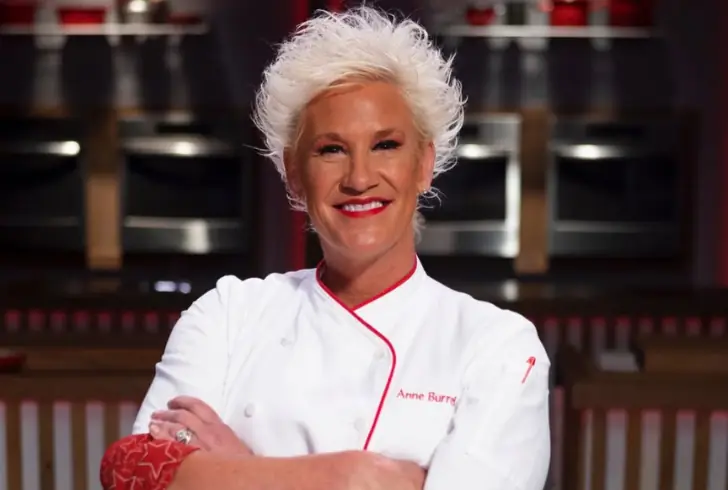 Anne Burrell in chef coat on Food Network set